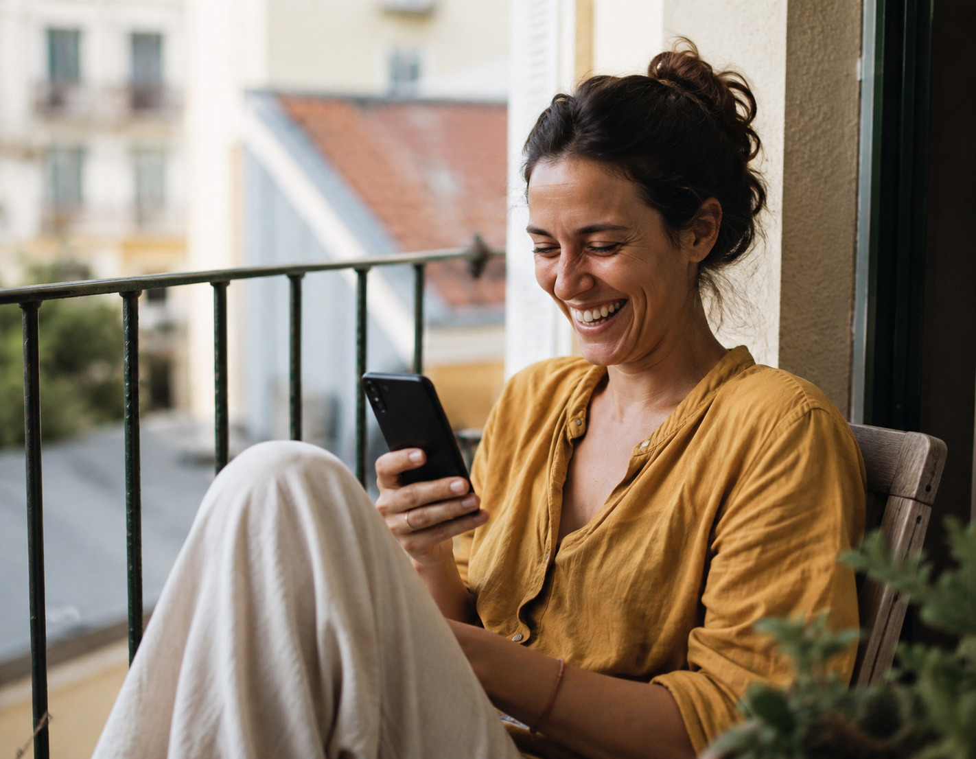 A woman smiles while reading a new message on a dating app on her phone