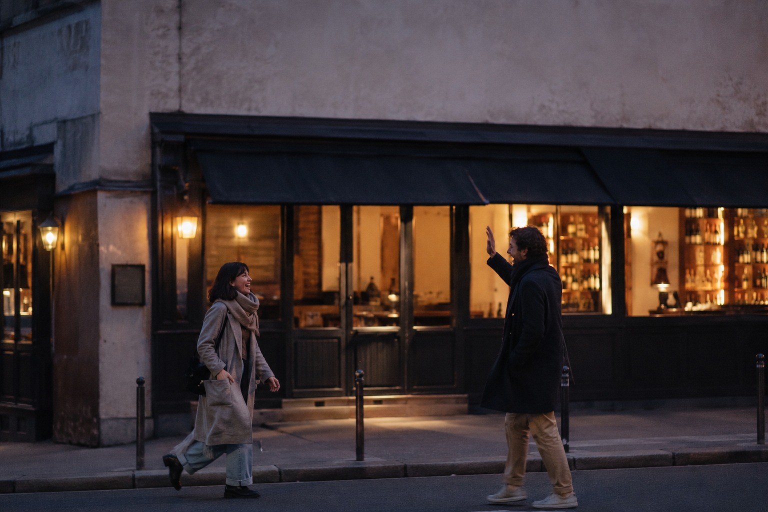 Two people who met on a dating site greet each other outside a wine bar in the evening